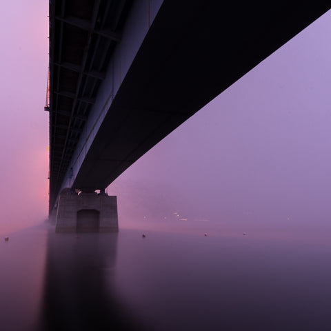a-bridge-sitting-in-thick-pink-and-purple-fog